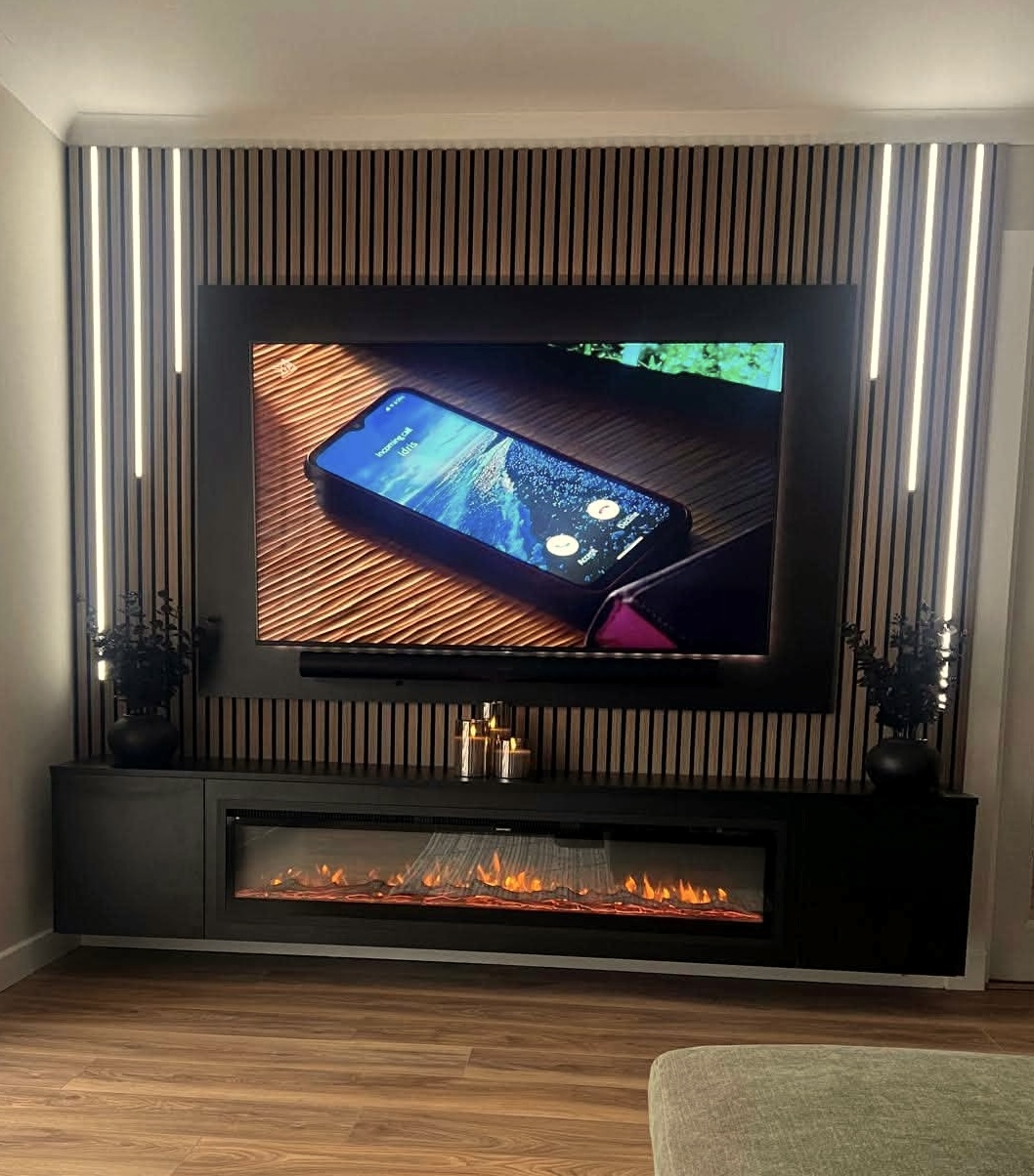 Bespoke black slat media wall with fire-effect and integrated TV by Baillie Installations